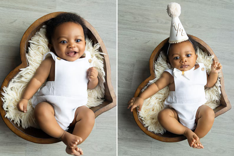 Two images of a baby in a wooden bowl with a white fluffy cushion, one wearing a white outfit and the other with a party hat.