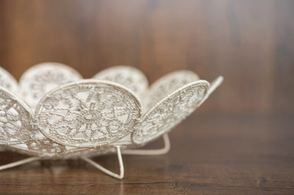 Decorative silver bowl with intricate patterns on a wooden surface