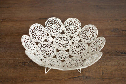 Decorative white lace bowl on a wooden surface