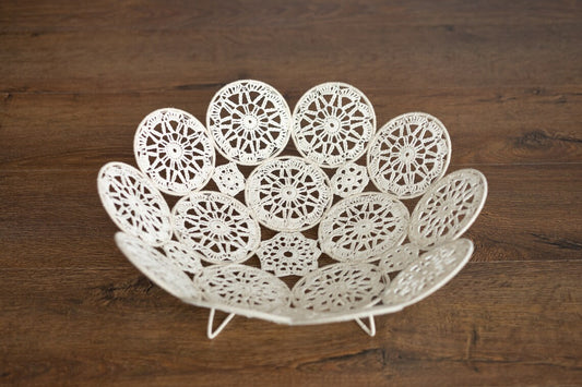 Decorative white lace bowl on a wooden surface