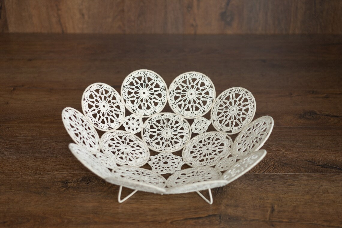 Decorative white lace bowl on a wooden surface