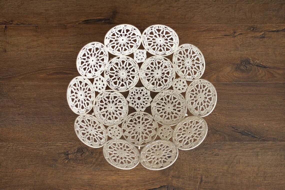 Circular arrangement of white lace doilies on a wooden surface