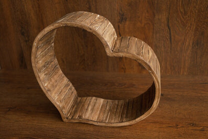 Wooden heart-shaped object on a wooden surface with a wooden background