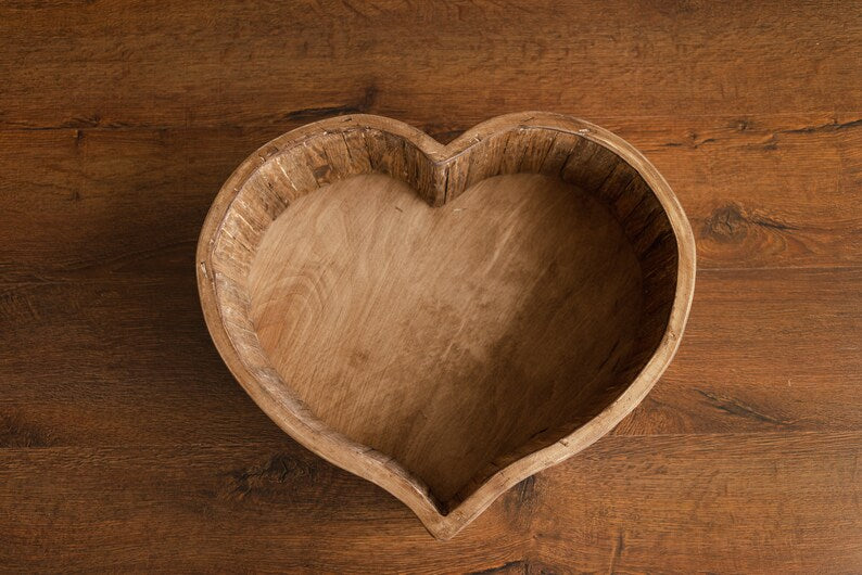 Wooden heart-shaped bowl on a wooden surface