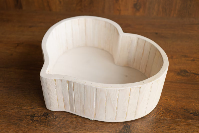 Heart-shaped wooden bowl on a wooden surface