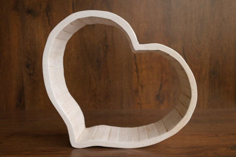 Heart-shaped wooden object on a wooden background